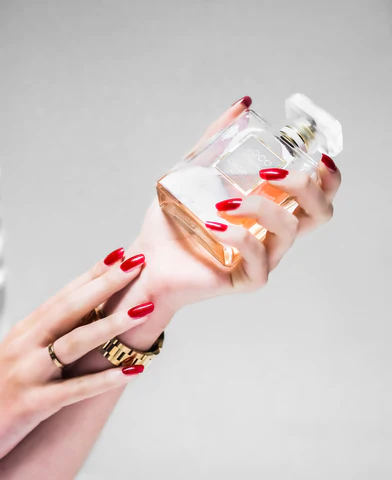 woman applying perfume on arm